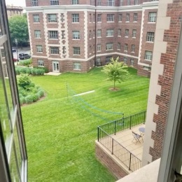 a balcony view of a courtyard with grass